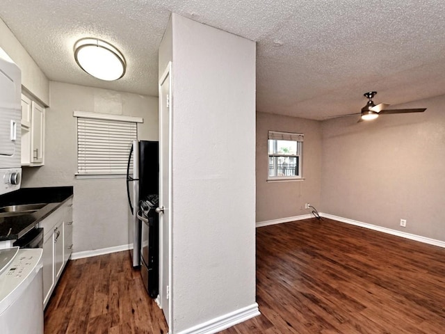 kitchen featuring white cabinetry, black gas range oven, dark wood-style floors, and baseboards