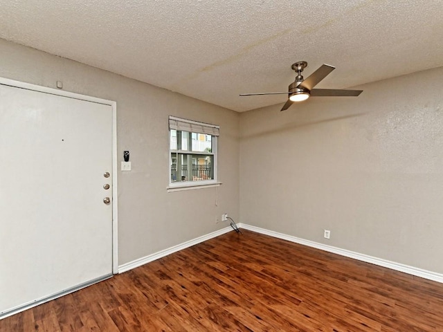 interior space with ceiling fan, baseboards, a textured ceiling, and wood finished floors