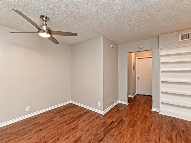 spare room featuring visible vents, a textured ceiling, wood finished floors, baseboards, and ceiling fan