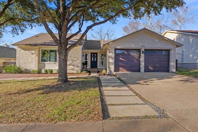 single story home with concrete driveway and an attached garage