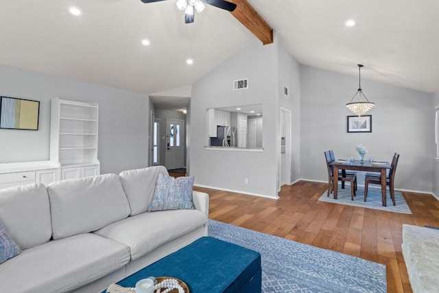 living room featuring visible vents, beamed ceiling, baseboards, and hardwood / wood-style floors