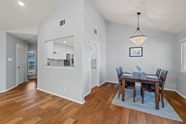 dining area featuring wood finished floors, visible vents, and baseboards