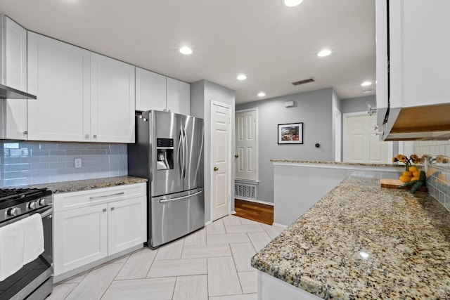 kitchen featuring light stone counters, visible vents, white cabinets, and appliances with stainless steel finishes