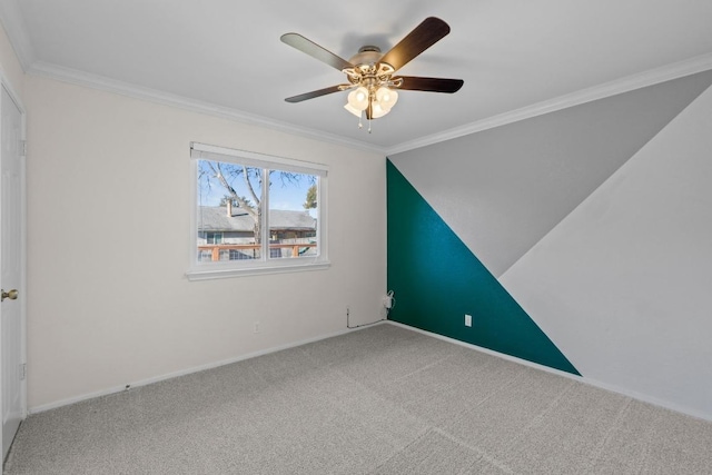 spare room featuring baseboards, carpet, ceiling fan, and crown molding