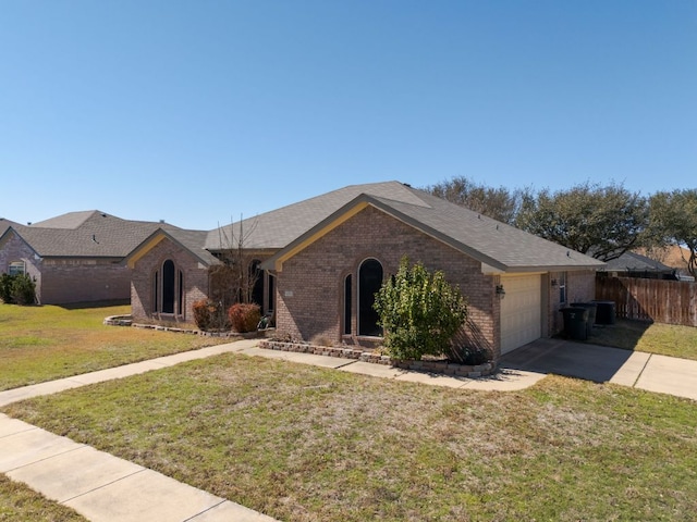 ranch-style home featuring fence, driveway, a front lawn, a garage, and brick siding