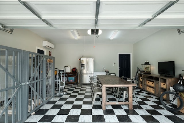 garage with a garage door opener, stainless steel fridge, and a wall mounted air conditioner