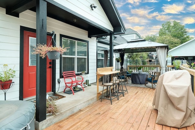 wooden terrace with a gazebo, grilling area, and a porch