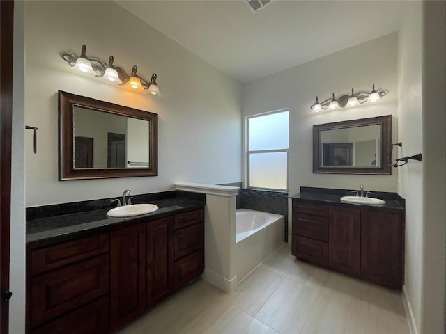 bathroom featuring a sink, a garden tub, two vanities, and tile patterned floors