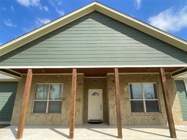 view of front facade with stone siding and covered porch