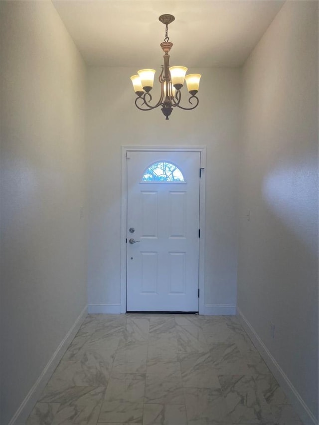 entryway featuring baseboards, a notable chandelier, and marble finish floor