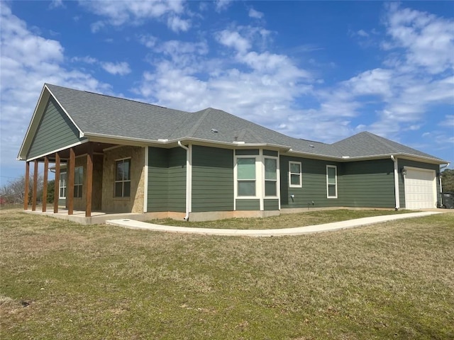 view of home's exterior with a yard, a garage, and roof with shingles