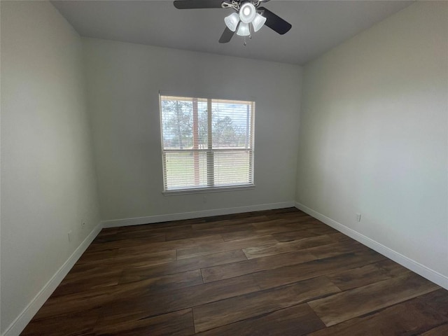 spare room with ceiling fan, baseboards, and dark wood-style flooring