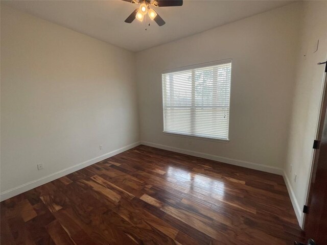 spare room featuring ceiling fan, baseboards, and dark wood-style floors