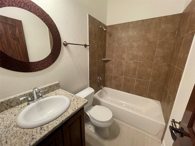 bathroom featuring bathing tub / shower combination, toilet, vanity, and a textured wall