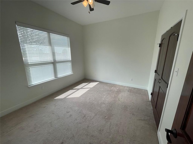 unfurnished bedroom with baseboards, carpet, and a ceiling fan