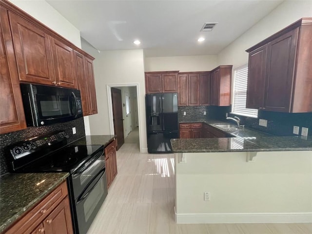 kitchen featuring visible vents, backsplash, dark stone counters, a peninsula, and black appliances