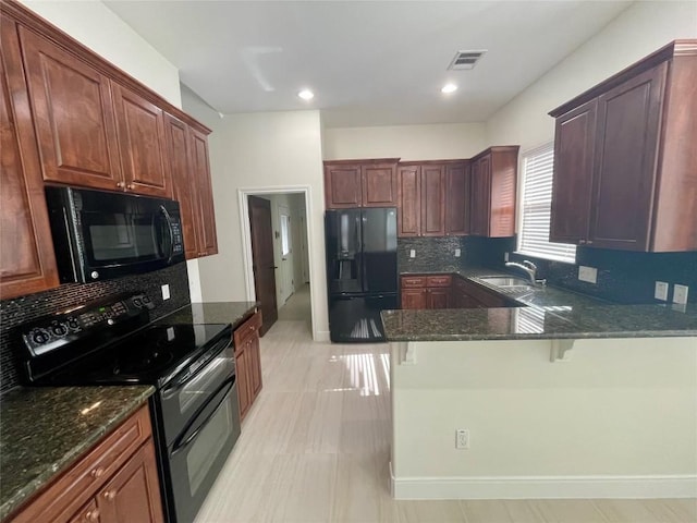 108 E Tanglebriar Ct, Bastrop, TX 78602 - kitchen featuring black appliances, tasteful backsplash, a peninsula, dark stone countertops, and recessed lighting