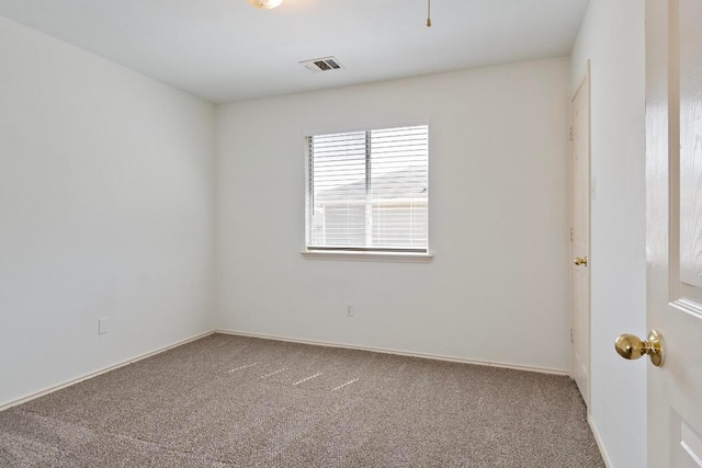 carpeted empty room featuring visible vents and baseboards