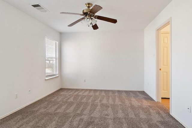 spare room featuring visible vents, carpet floors, and ceiling fan