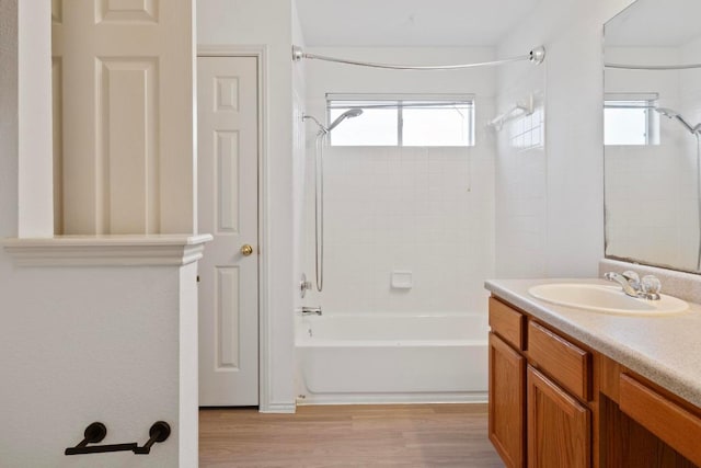 full bath with a wealth of natural light, shower / tub combination, wood finished floors, and vanity