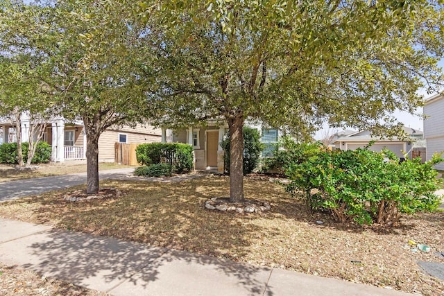 view of property hidden behind natural elements with fence