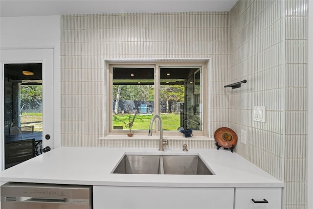 kitchen with a sink, tile walls, dishwasher, and light countertops