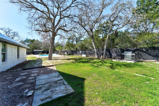 view of yard with a fenced in pool, a fenced backyard, and a patio area