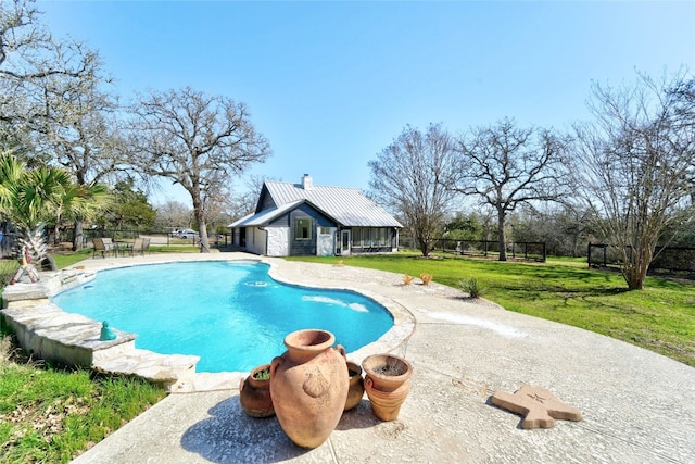 view of pool with a fenced in pool, fence, an outdoor structure, a patio area, and a lawn