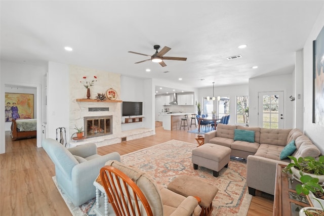 living area featuring recessed lighting, a fireplace, and light wood finished floors