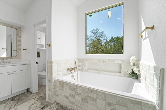 bathroom with a bath, marble finish floor, toilet, and vanity