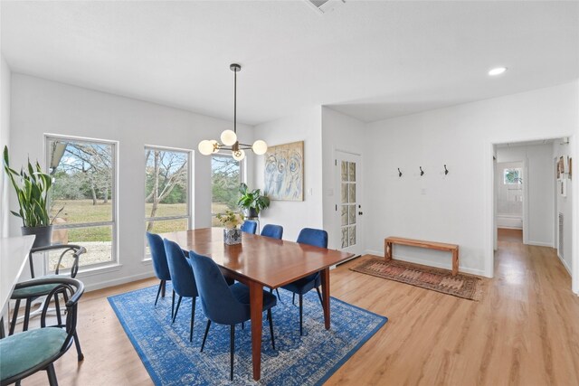 dining room with a wealth of natural light, baseboards, and light wood-style floors