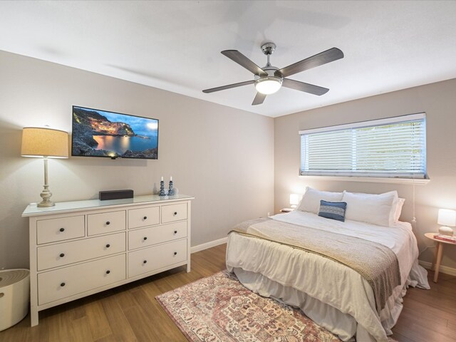 bedroom with baseboards, wood finished floors, and a ceiling fan