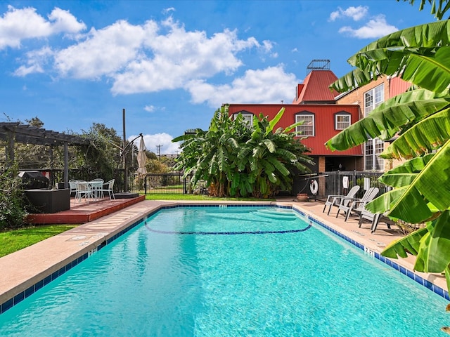 pool featuring fence and a pergola