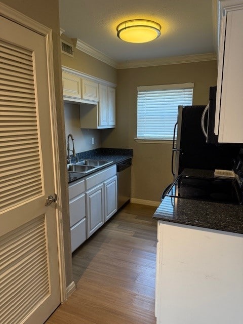 900 S Lamar Blvd Unit 205, Austin, TX 78704 - kitchen with appliances with stainless steel finishes, dark countertops, white cabinetry, ornamental molding, and dark wood-type flooring