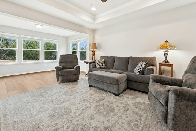 living room with baseboards, a tray ceiling, ornamental molding, recessed lighting, and wood finished floors