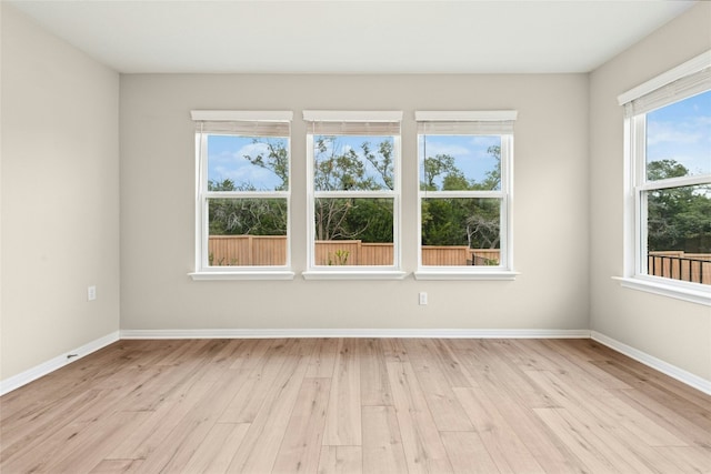 empty room with light wood-style flooring and baseboards