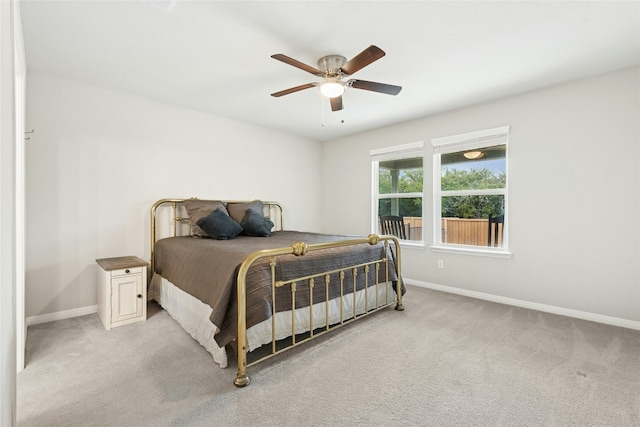 bedroom featuring light carpet, a ceiling fan, and baseboards