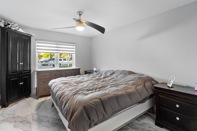 bedroom featuring a ceiling fan and marble finish floor