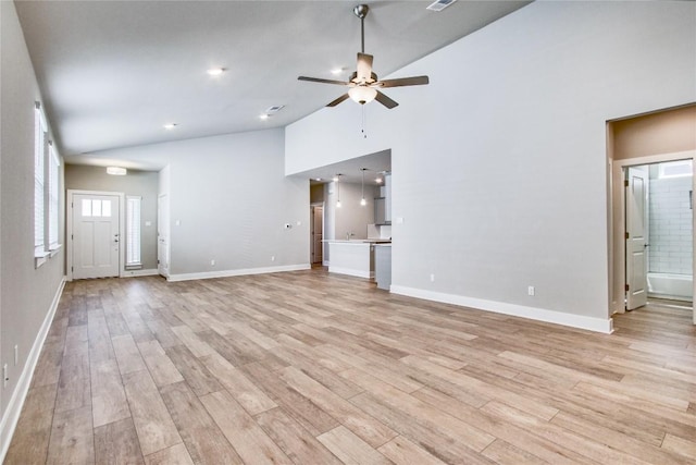 unfurnished living room featuring light wood-type flooring, baseboards, high vaulted ceiling, and a ceiling fan