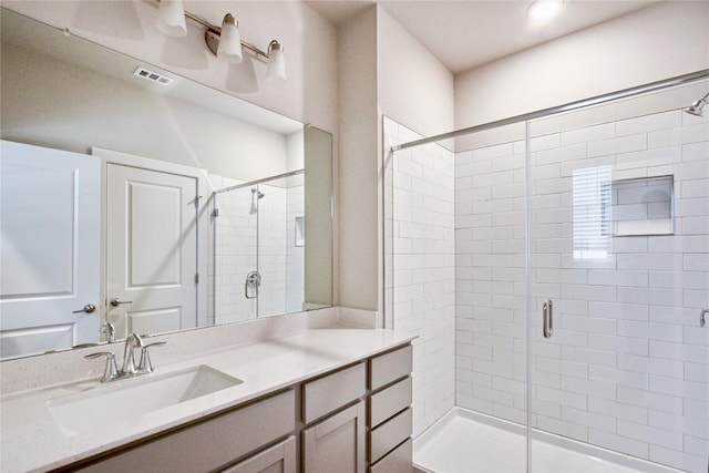 bathroom featuring visible vents, vanity, and a shower stall