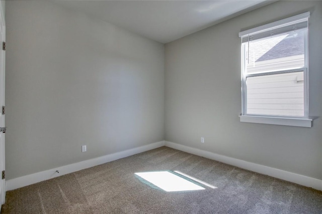 empty room featuring baseboards and carpet floors