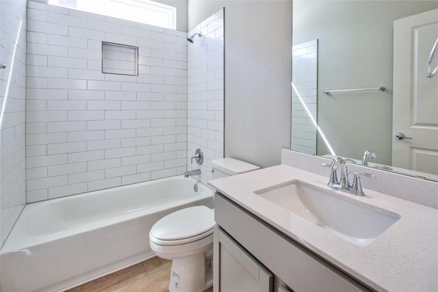 bathroom featuring wood finished floors, toilet, vanity, and washtub / shower combination