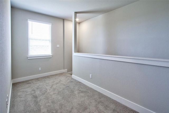 carpeted empty room with baseboards