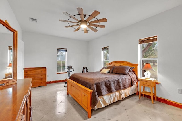 bedroom with light tile patterned floors, visible vents, multiple windows, and baseboards