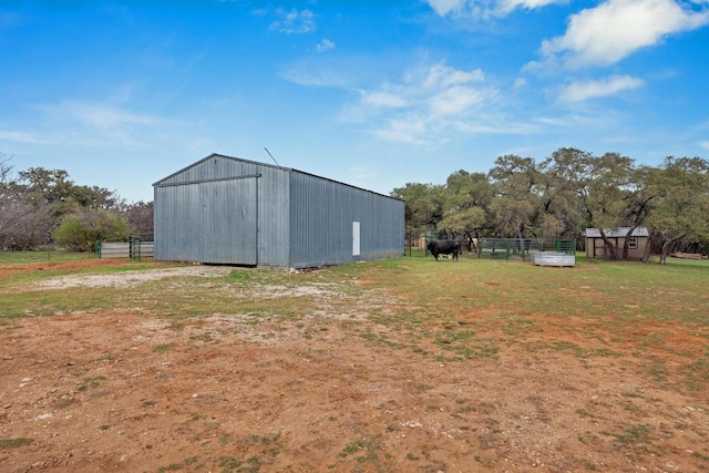 view of yard with an outbuilding, a rural view, and fence