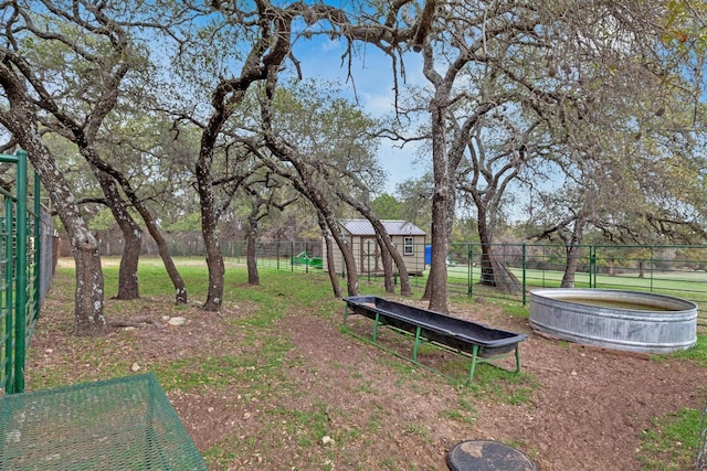 surrounding community featuring a fenced backyard, a lawn, an outdoor structure, and a trampoline