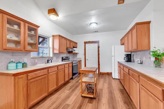 kitchen featuring under cabinet range hood, tile countertops, electric stove, and a sink