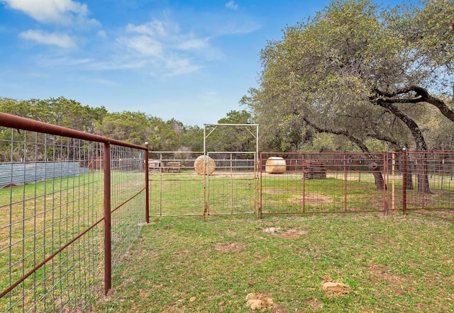 view of yard with a gate, a rural view, and fence