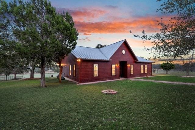 view of front of property featuring a yard and metal roof