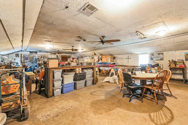 interior space featuring a workshop area, visible vents, and ceiling fan